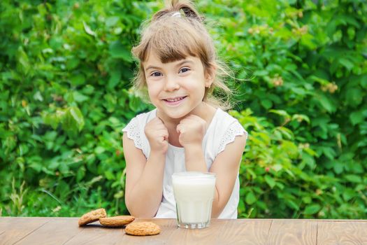 The child drinks milk and cookies. Selective focus.