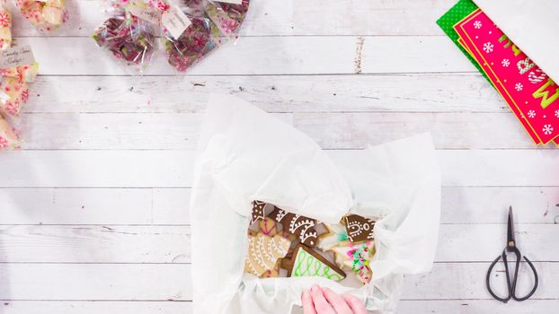 Flat lay. Step by step. Packaging homemade fudge and cookies into a Christmas gift box.