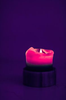 Happy holidays, greeting card backdrop and winter season concept - Pink holiday candle on purple background, luxury branding design and decoration for Christmas, New Years Eve and Valentines Day