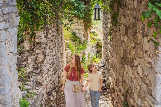 Mom and son tourists walks through the old town of Bar in Montenegro. Happy tourist walks in the mountains. Suburbs of the city of Bar, Montenegro, Balkans. Beautiful nature and landscape.