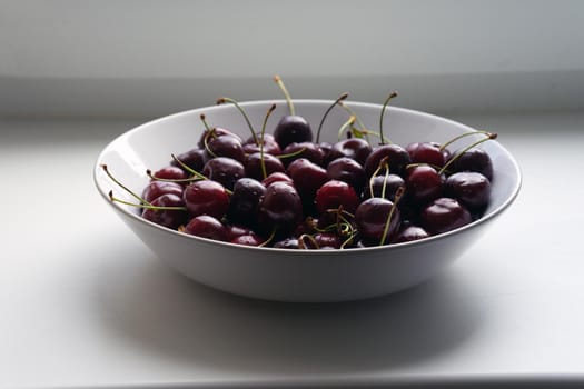 Large white glass plate full of cherries. High quality photo