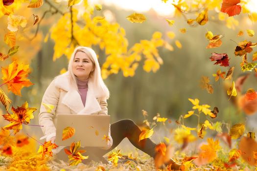 Beautiful girl walking outdoors in autumn. Smiling girl collects yellow leaves in autumn. Young woman enjoying autumn weather. High quality photo