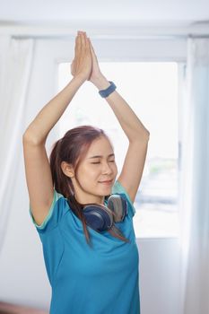 stress relief, muscle relaxation, breathing exercises, exercise, meditation, portrait of Young Asian woman relaxing her body from office work by practicing yoga by watching online tutorials