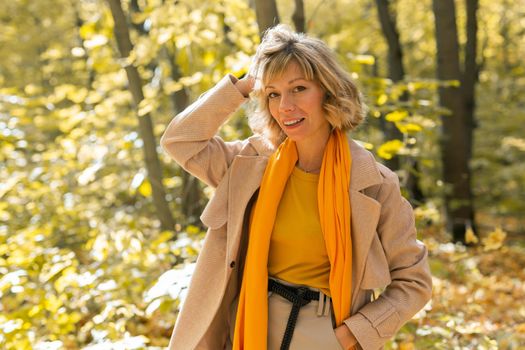 Autumn woman in fall season park. Warm sunny weather