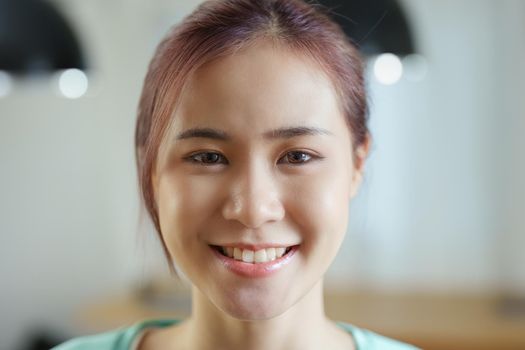 Portrait of a young Asian woman showing a happiness smiling face.