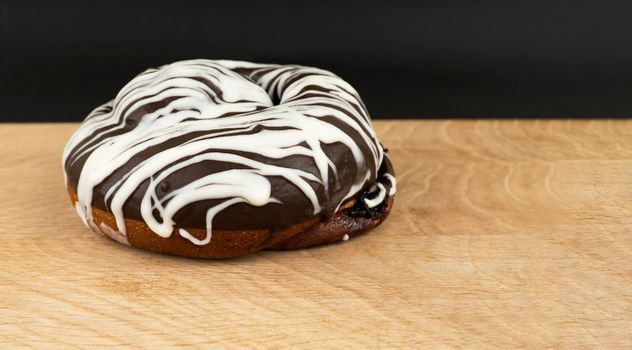 bun covered with chocolate on a wooden board