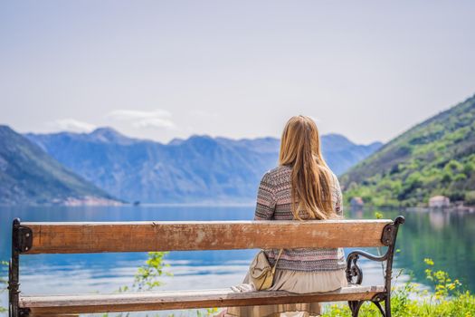 A woman sits on a bench and admires the view of the Bay of Kotor. Montenegro.