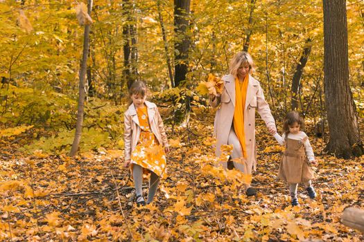 Mother and little daughter enjoying nice autumn day in a park. Season, family and children