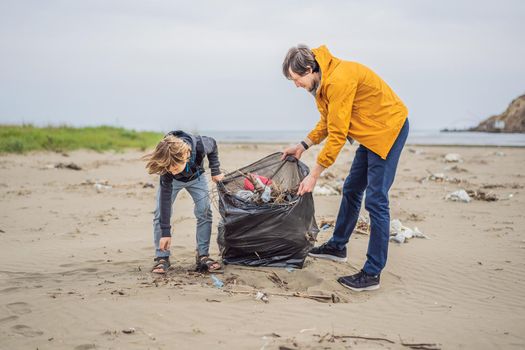 Dad and son in gloves cleaning up the beach pick up plastic bags that pollute sea. Natural education of children. Problem of spilled rubbish trash garbage on the beach sand caused by man-made.