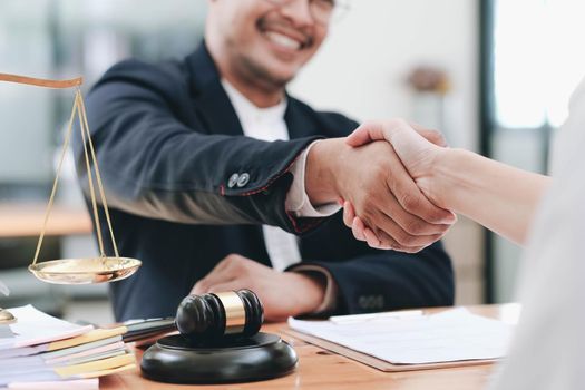 Businessman shaking hands to seal a deal with his partner lawyers or attorneys discussing a contract agreement..