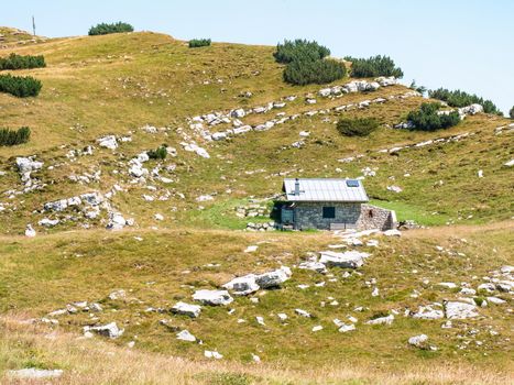 Stony holiday cottage hidden in meadow close to peak of Canfedin mountain 1865 metres high. Vezzano region, Trentino, Italy