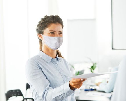 portrait of a young business woman wearing a protective mask in the office