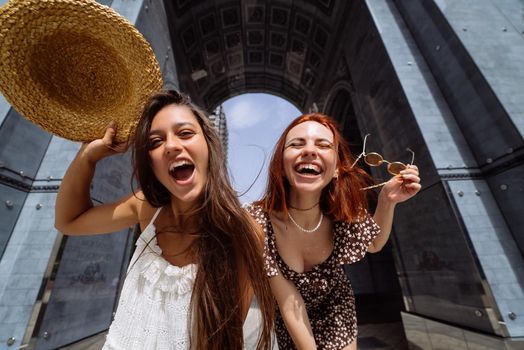 Portrait of two young beautiful smiling hipster female in trendy summer clothes.Sexy carefree women posing on street background.
