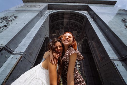 Portrait of two young beautiful smiling hipster female in trendy summer clothes.Sexy carefree women posing on street background.