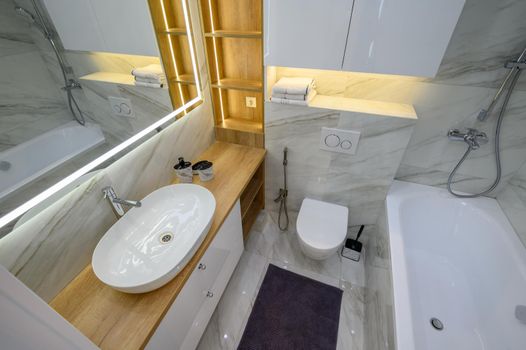 Luxury bathroom interior with marble tiles on the walls and a large mirror, low angle view