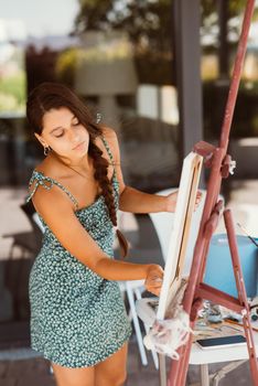 Female artist painting picture in workshop