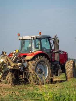 farmer with tractor plowing the land in the countryside.