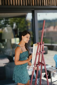 Female artist painting picture in workshop