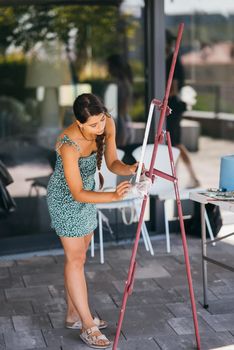 Female artist painting picture in workshop