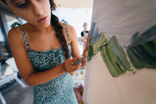 Female artist painting picture in workshop