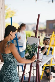 Female artist painting picture in workshop