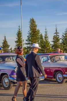 2022-08-12 Tatarstan, Verkhneuslonsky district, Savino village. Resort town "Sviyazhsky hills". Kazan Festival of Historical Cars. A man and a woman in retro clothes pose near cars