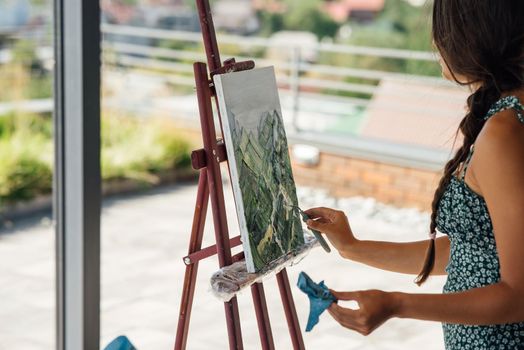 Female artist painting picture in workshop