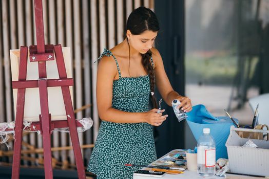 Woman squeezing Paint Tube in ART-class