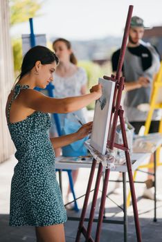 Female artist painting picture in workshop