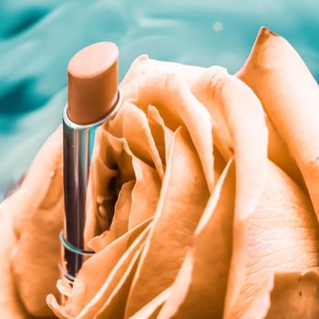 Cosmetic branding, luxe and fashion concept - Yellow lipstick and rose flower on liquid background, waterproof glamour make-up and lip gloss cosmetics product for luxury beauty brand holiday design