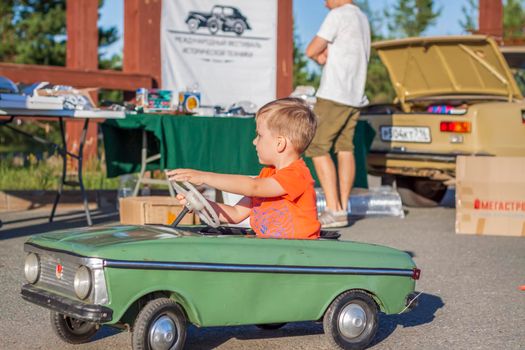 2022-08-12 Tatarstan, Verkhneuslonsky district, village. Savino. Resort town "Sviyazhsky hills". Kazan Festival of Historical Technologies. Children ride on children's retro cars.