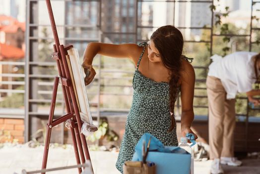 Female artist painting picture in workshop