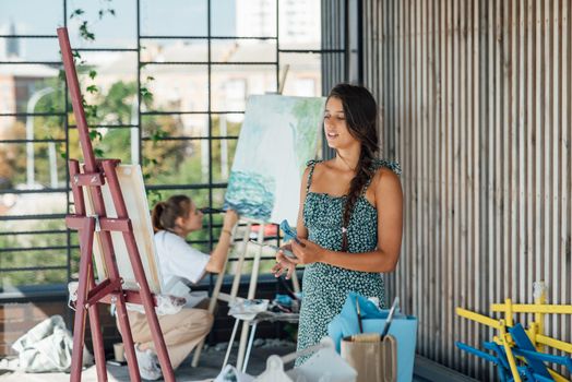 Female artist painting picture in workshop