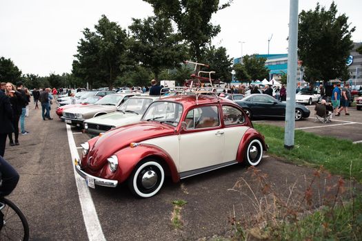 Genk, BELGIUM, August 18, 2021: classic summer meet of oldtimer at The Luminus Arena Genk, red and grey volkswagen beetle, High quality photo