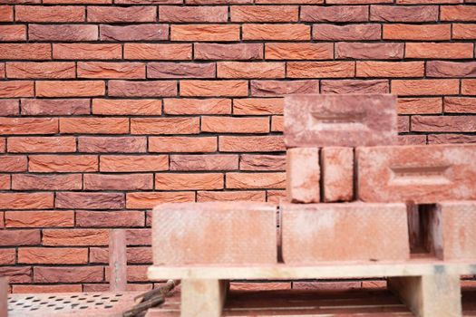 a new House is being built, the beginning of brickwork with red bricks, building materials, a pattern of stones, a natural background. High quality photo