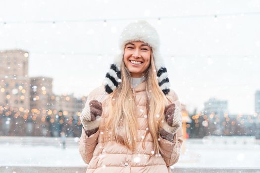Happy winter time in big city charming girl standing street dressed funny fluffy hat. Enjoying snowfall, expressing positivity, smiling to camera, joyful cheerful mood, true emotions, Christmas mood