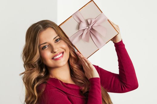 Holiday present for birthday, baby shower, wedding or luxury beauty box subscription delivery, happy woman holding a wrapped pink gift on white background