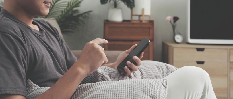 Close up hand of man using smartphone at home.