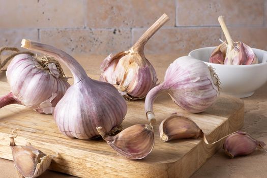 Close-up of the head and cloves of garlic lie on a cutting board. Selective focus.