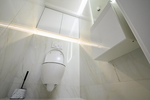 New ceramic toilet bowl in a white toilet room interior