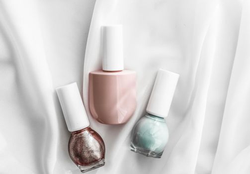 Cosmetic branding, salon and glamour concept - Nail polish bottles on silk background, french manicure products and nailpolish make-up cosmetics for luxury beauty brand and holiday flatlay art design