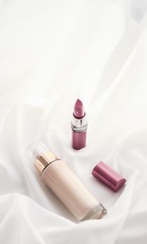 Cosmetic branding, glamour and skincare concept - Beige tonal cream bottle make-up fluid foundation base and pink lipstick on silk background, cosmetics products as luxury beauty brand holiday design