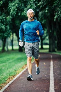 portrait of a senior man exercising and running outdoors