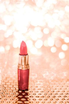 Cosmetic branding, sale and glamour concept - Coral lipstick on rose gold Christmas, New Years and Valentines Day holiday glitter background, make-up and cosmetics product for luxury beauty brand