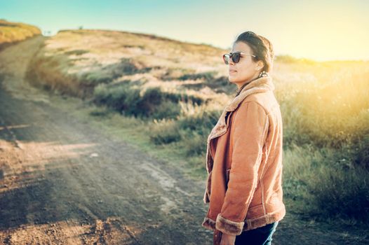 Lifestyle of a Latin girl on a road outdoors. Portrait of a young woman on a road, Close-up of a young woman on the road, woman on a road. Latina girl woman concept on a dirt road