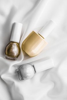 Cosmetic branding, salon and glamour concept - Nail polish bottles on silk background, french manicure products and nailpolish make-up cosmetics for luxury beauty brand and holiday flatlay art design