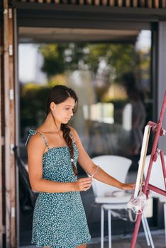 Female artist painting picture in workshop