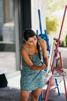 Female artist painting picture in workshop