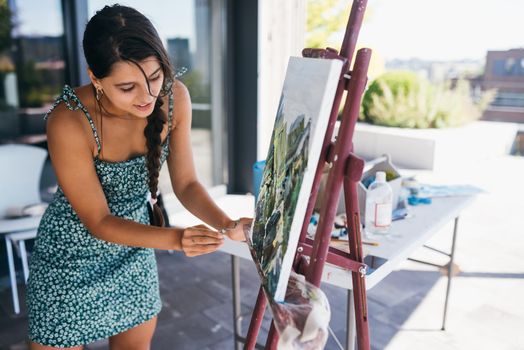 Female artist painting picture in workshop