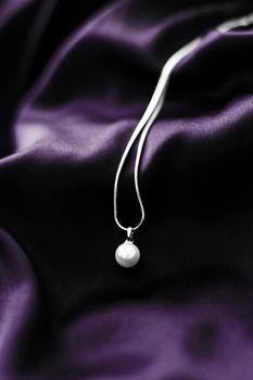 Jewellery brand, elegant fashion and bridal luxe gift concept - Luxury white gold pearl necklace on dark violet silk background, holiday glamour jewelery present